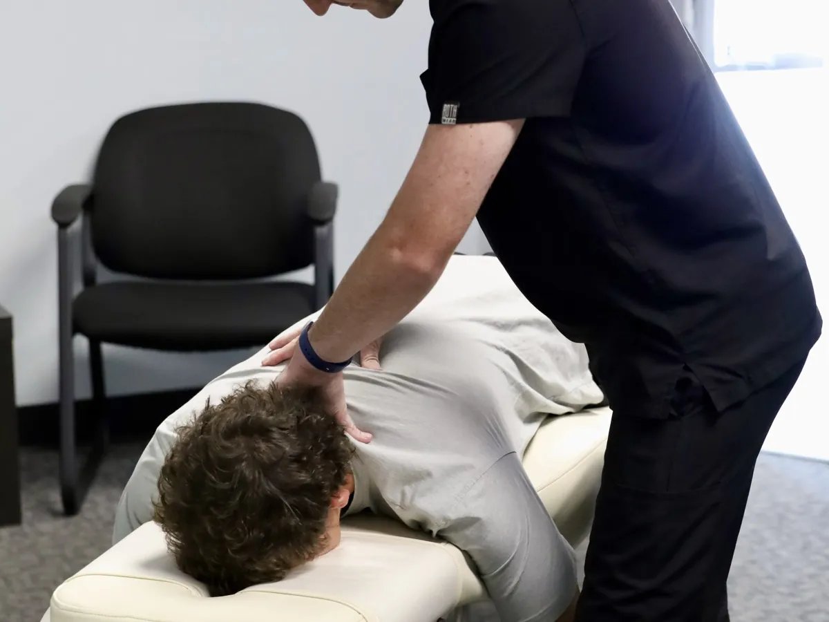Dr. Hyatt Frost adjusting a teen's mid-back at his chiropractic office in Tulsa, OK